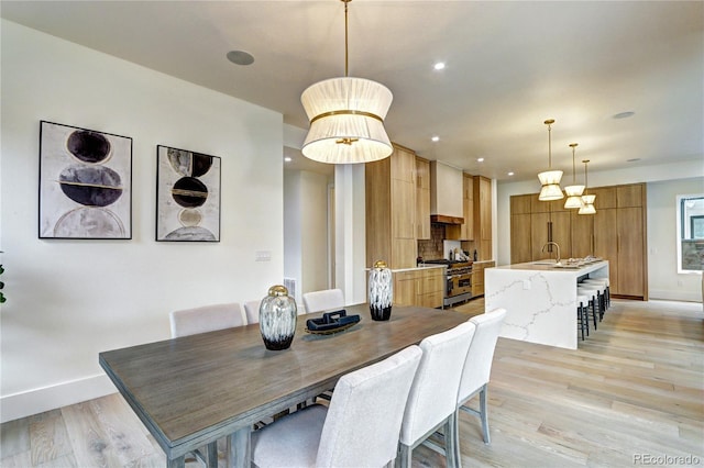 dining area featuring sink and light wood-type flooring