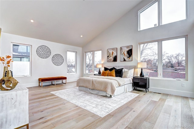 bedroom featuring high vaulted ceiling and light hardwood / wood-style flooring