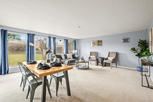 dining area featuring light colored carpet, a textured ceiling, and baseboards