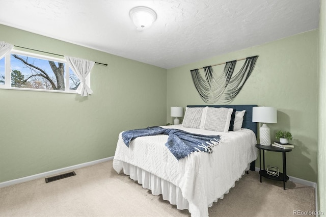 carpeted bedroom featuring baseboards, visible vents, and a textured ceiling