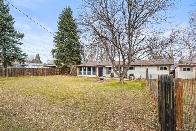 exterior space featuring a yard, a fenced backyard, and a sunroom