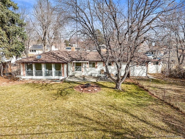 back of property with an outdoor fire pit, a lawn, a sunroom, a chimney, and fence