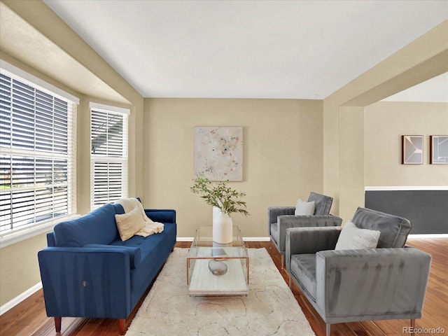 living area with baseboards and wood finished floors