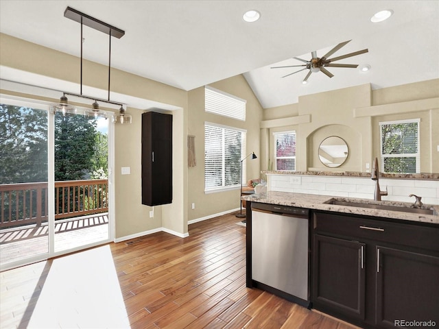 kitchen featuring dishwasher, a sink, a ceiling fan, vaulted ceiling, and light wood-type flooring