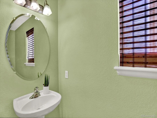 bathroom featuring a sink and a textured wall