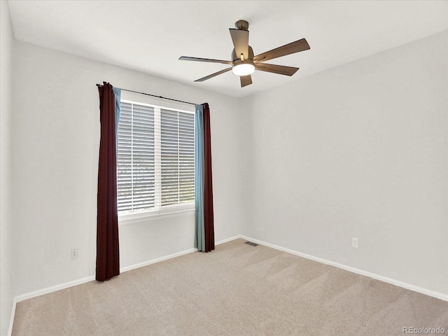 unfurnished room with carpet floors, a ceiling fan, and baseboards