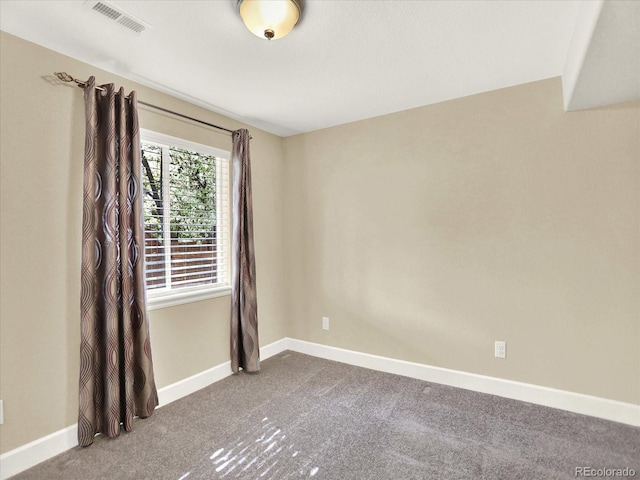 carpeted spare room featuring baseboards