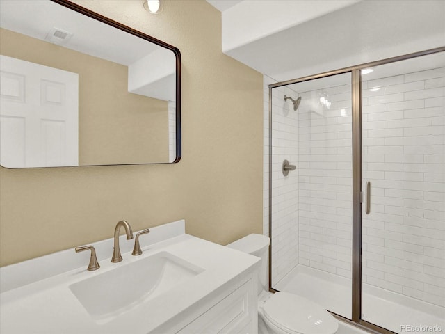 full bath with a stall shower, toilet, and vanity