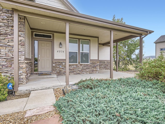 view of exterior entry featuring covered porch