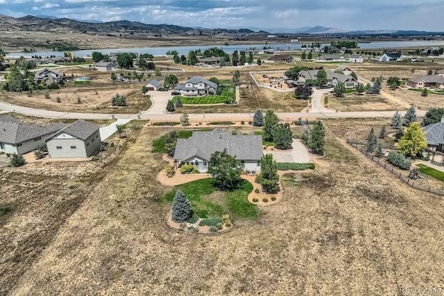 drone / aerial view featuring a water and mountain view