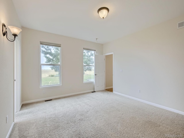 carpeted spare room featuring plenty of natural light