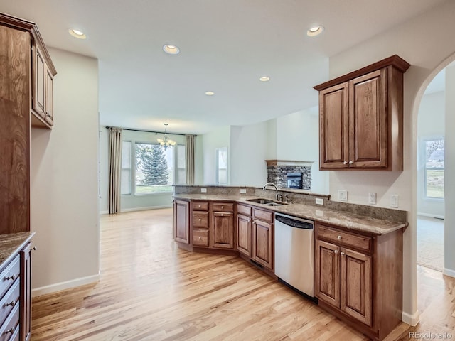 kitchen with a wealth of natural light, light hardwood / wood-style flooring, and stainless steel dishwasher