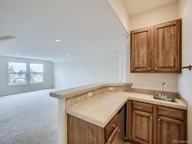 kitchen with sink, tile counters, carpet flooring, and kitchen peninsula