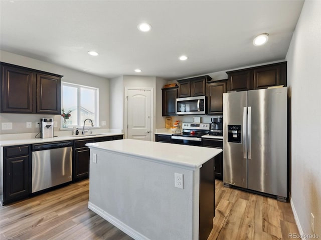 kitchen featuring stainless steel appliances, a sink, light countertops, dark brown cabinets, and recessed lighting