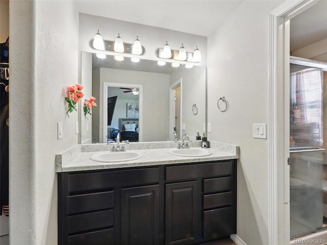ensuite bathroom with double vanity, ceiling fan, and a shower stall