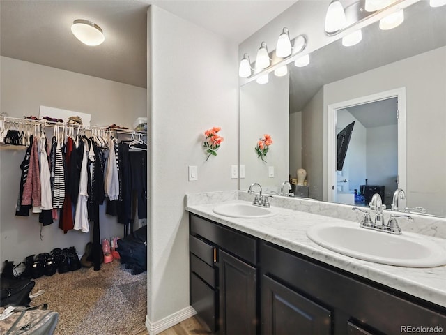 full bathroom with double vanity and a spacious closet