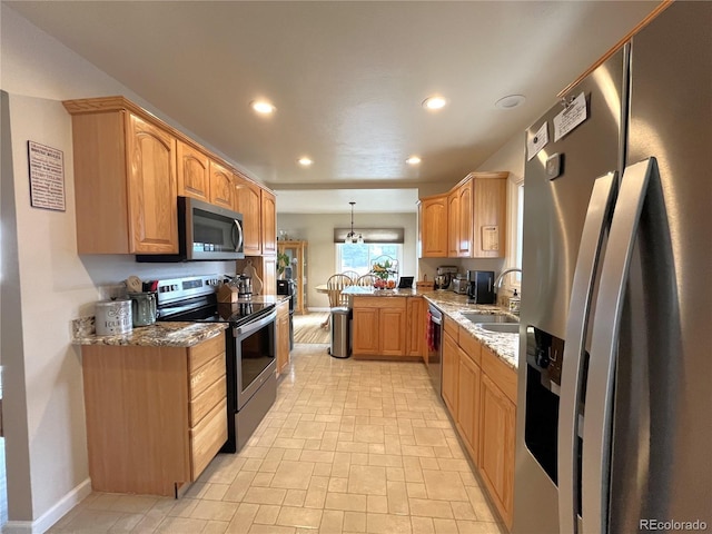 kitchen with stone counters, recessed lighting, appliances with stainless steel finishes, and a sink