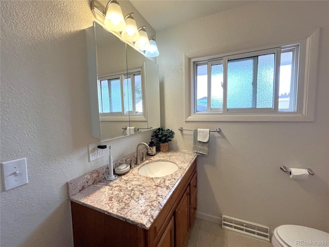 bathroom with visible vents, plenty of natural light, vanity, and tile patterned flooring