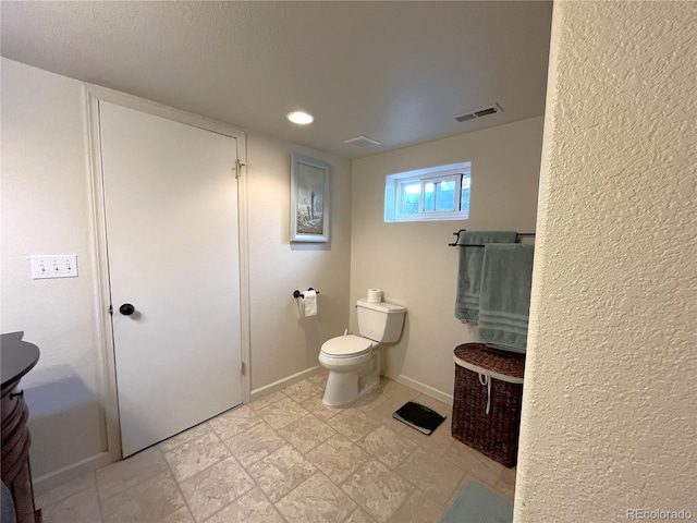 bathroom featuring visible vents, toilet, and baseboards