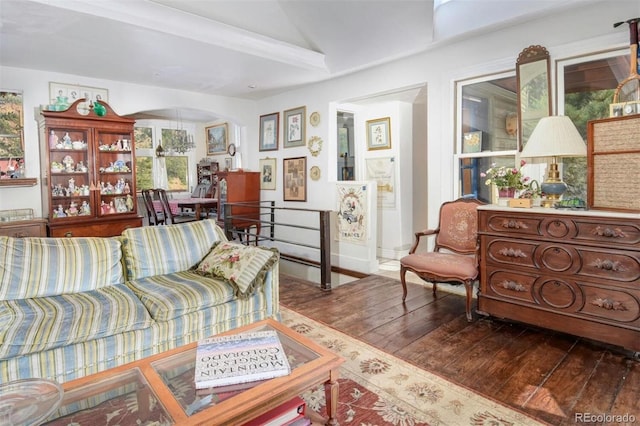 living area with arched walkways, baseboards, and hardwood / wood-style floors