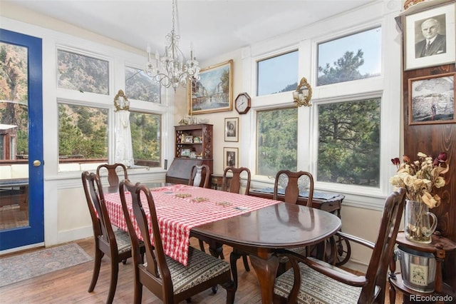 dining space with a chandelier, plenty of natural light, and light wood-style flooring