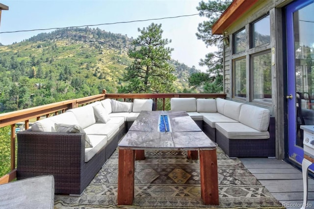 deck with a view of trees and an outdoor hangout area