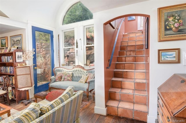 stairs featuring arched walkways and hardwood / wood-style floors