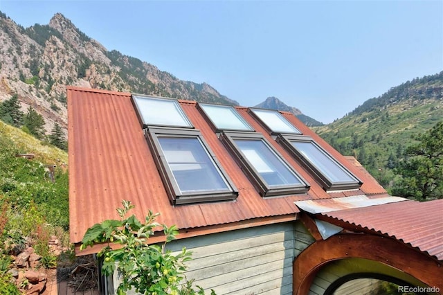 view of side of home with a mountain view and metal roof