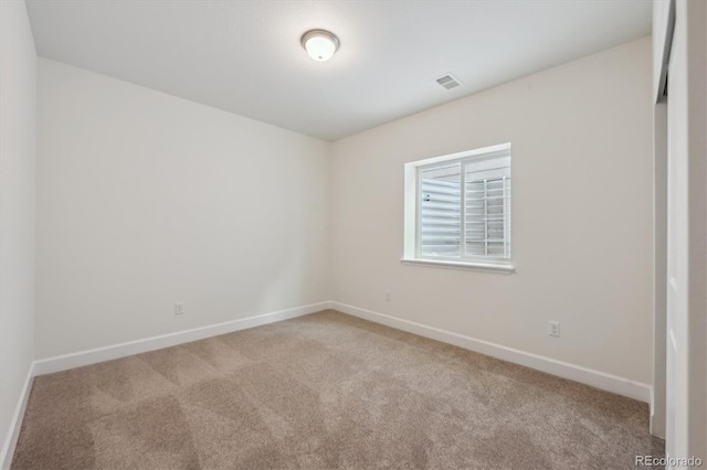 spare room featuring light colored carpet