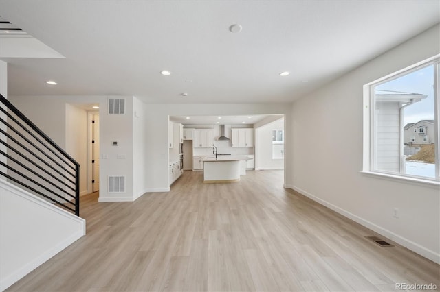 unfurnished living room with light hardwood / wood-style floors and sink