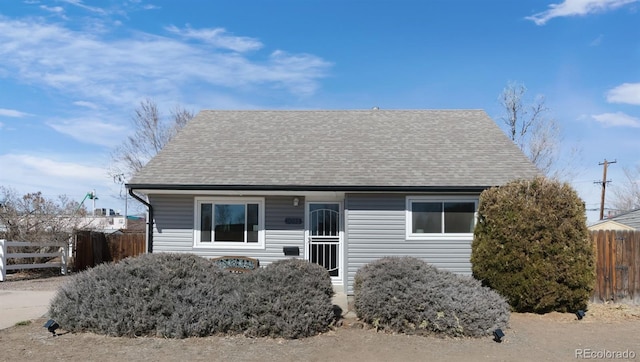 view of front of home featuring fence and a shingled roof