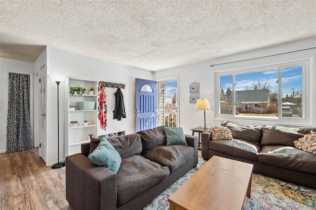 living room with a textured ceiling and wood finished floors