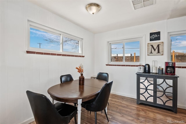 dining space featuring visible vents, baseboards, and wood finished floors