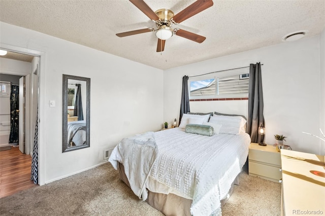 bedroom with a textured ceiling, ceiling fan, and carpet floors