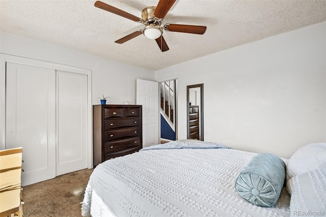 carpeted bedroom with a closet, a textured ceiling, and a ceiling fan