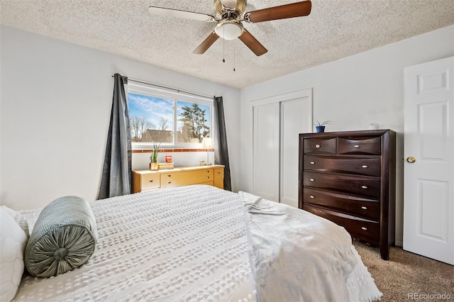 bedroom with a closet, a textured ceiling, carpet, and a ceiling fan