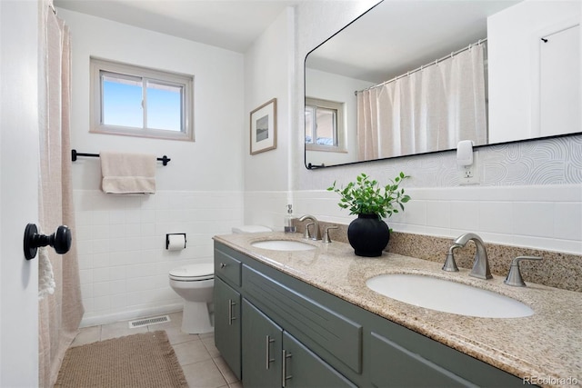 bathroom featuring vanity, tile walls, tile patterned floors, and toilet