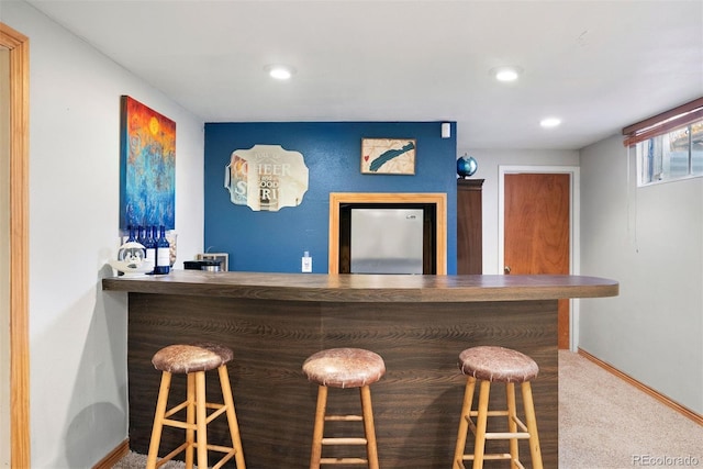 bar featuring carpet floors and stainless steel refrigerator