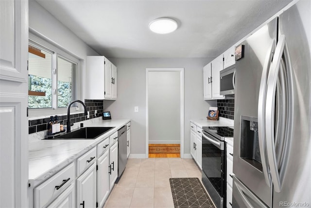 kitchen featuring white cabinetry, stainless steel appliances, sink, and backsplash