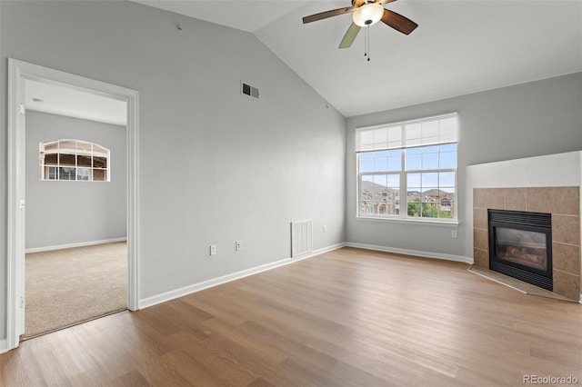 7440 S Blackhawk St Unit 207, Englewood, CO 80112 - unfurnished living room featuring wood finished floors, ceiling fan, a tiled fireplace, and vaulted ceiling