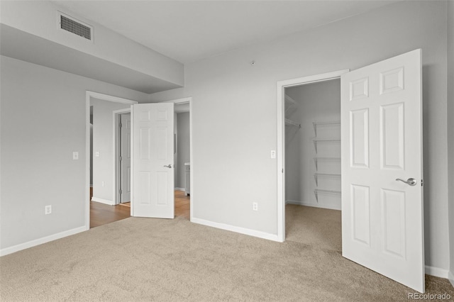 7440 S Blackhawk St Unit 207, Englewood, CO 80112 - unfurnished bedroom with carpet flooring, a walk in closet, and a closet