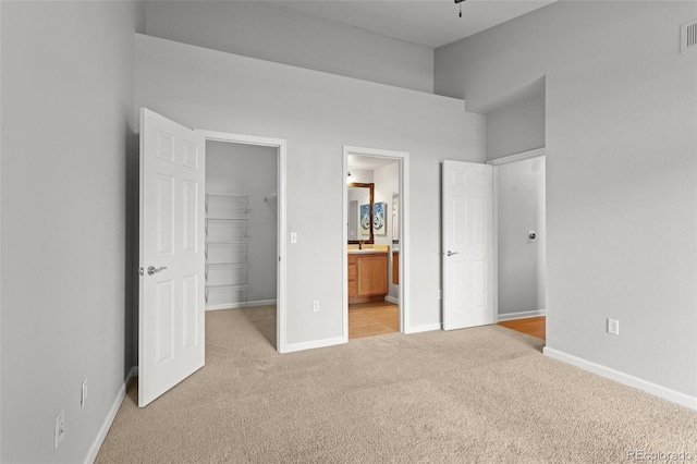 7440 S Blackhawk St Unit 207, Englewood, CO 80112 - unfurnished bedroom featuring light carpet, a walk in closet, a closet, and ensuite bathroom