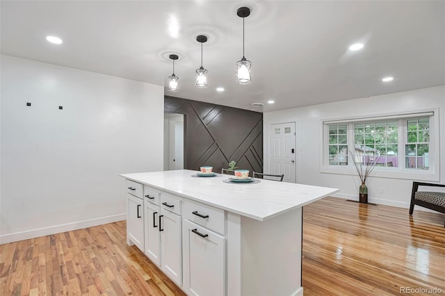 1325 Dayton St, Aurora, CO 80010 - kitchen with light wood finished floors, white cabinetry, a center island, hanging light fixtures, and recessed lighting