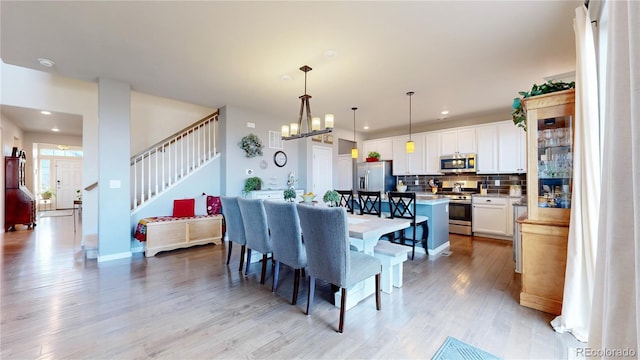 dining room featuring an inviting chandelier and light wood-type flooring