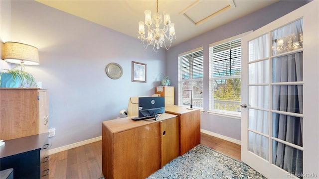 home office with a chandelier and hardwood / wood-style floors