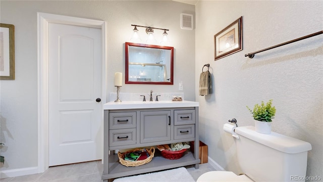 bathroom featuring vanity, tile patterned floors, and toilet