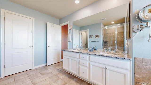 bathroom featuring tile patterned flooring, vanity, and a shower with shower door