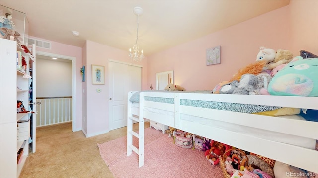 carpeted bedroom featuring an inviting chandelier