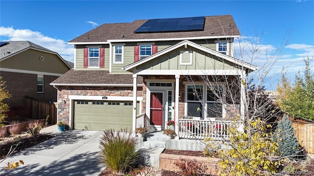 view of front of house featuring a garage, a porch, and solar panels