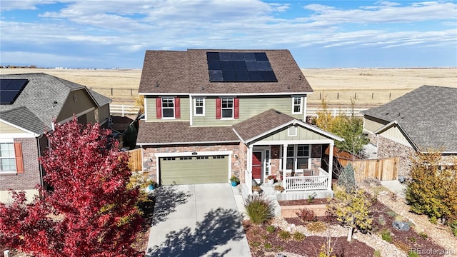 view of front of property featuring a porch, a garage, and solar panels